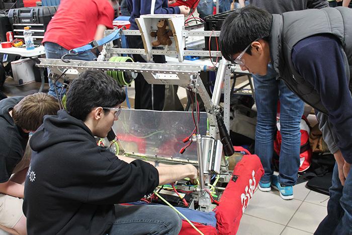 Robotics member work on their robot for the Mini Make Faire Showcase 