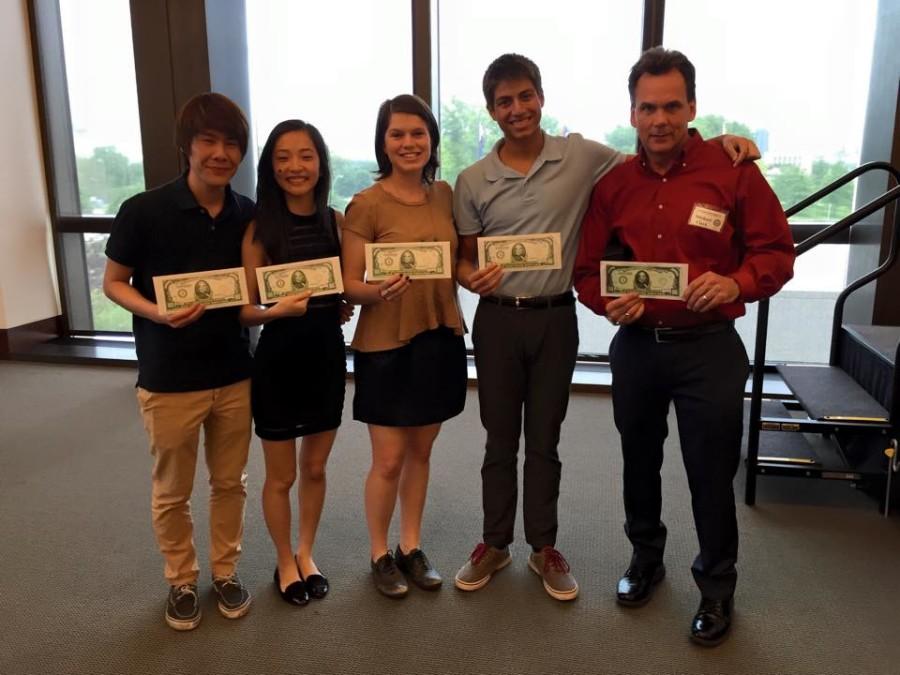 (From left to right) Seniors Kenneth Yu, Christina Mao,  Claire Weddle, Akash Shukla, and AP Economics teacher Micheal Clark cash out with their first place win in the national personal finance competition