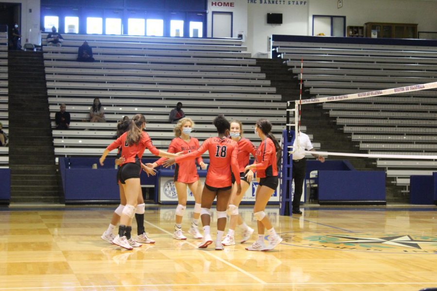 Varsity girl volleyball players huddle together to regroup after every point. 