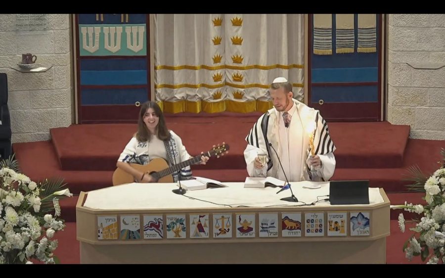 Junior+Nava+Teller+stands+on+the+stage+of+the+Brith+Shalom+Synagogue+as+she+leads+Havdala+during+the+Neilah+service.+Teller+focuses+on+the+congregation+and+enjoys+Yom+Kippur+despite+having+numerous+assignments+to+make+up+on+the+HUB.