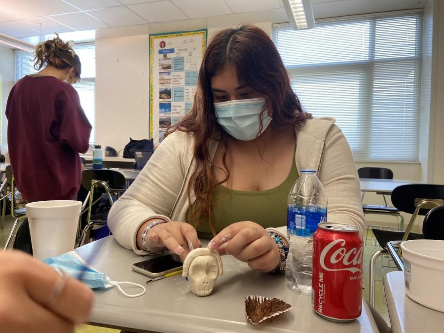 Sophomore Ella castillo molds a skull for Day of the Dead at the Spanish Club meeting. She molds the shape before painting the skull with vibrant colors.