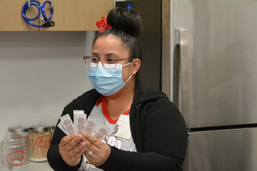 Bellaire clinics clerk Shirley Alfaro checks the amount of Band-Aids currently in stock in the cabinets every few days. Alfaro interacts with students as they come into the clinic before seeing the nurse.