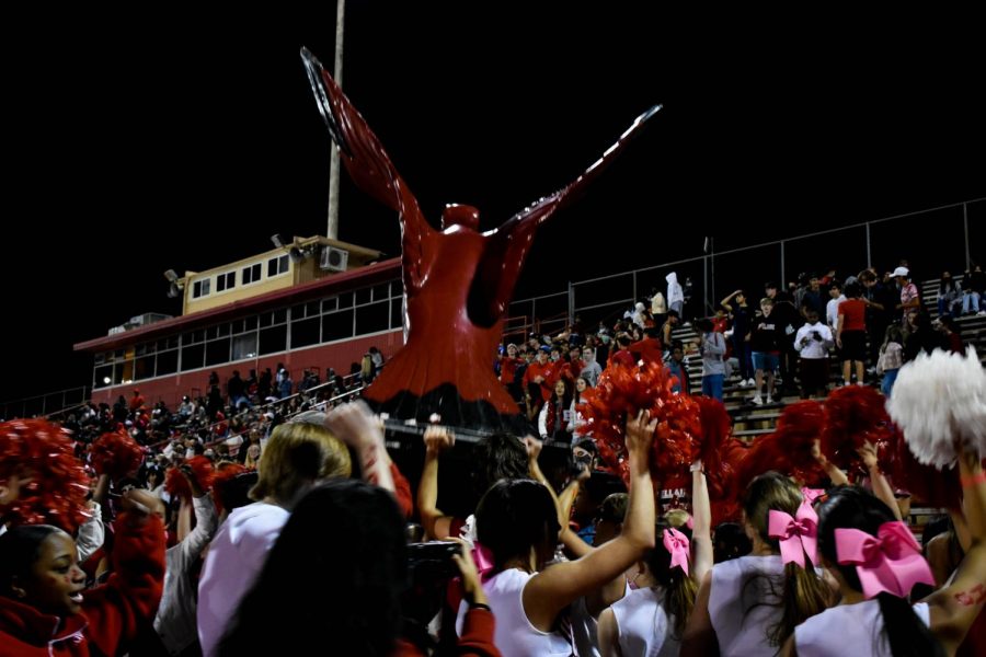 The Bird Keepers and Booster club celebrate Bellaire scoring a touchdown with cheerleaders and band. The Birdkeepers lifts Ralph, the cardinal to carry on tradition.