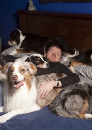 Six Australian Shepherds cuddle with English II teacher Brian Wolf. The dogs have been in his life for over ten years.