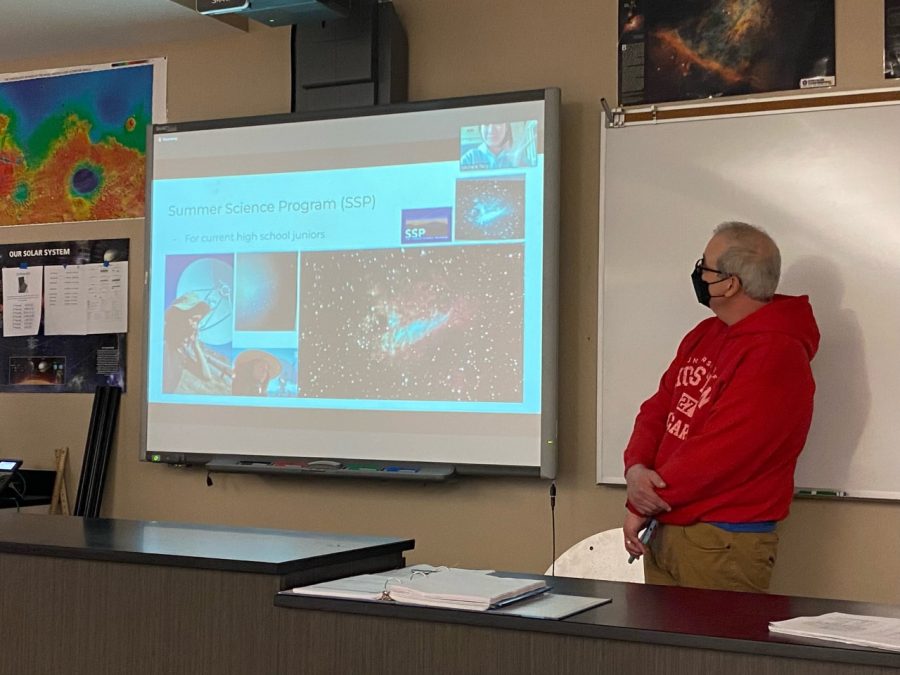 Mr. Newland stands close to the board, watching Michelle Tangs presentation. Michelle Tang speaks about taking part in the Science Space Program in New Mexico and shows her favorite picture of a Swan Nebula.