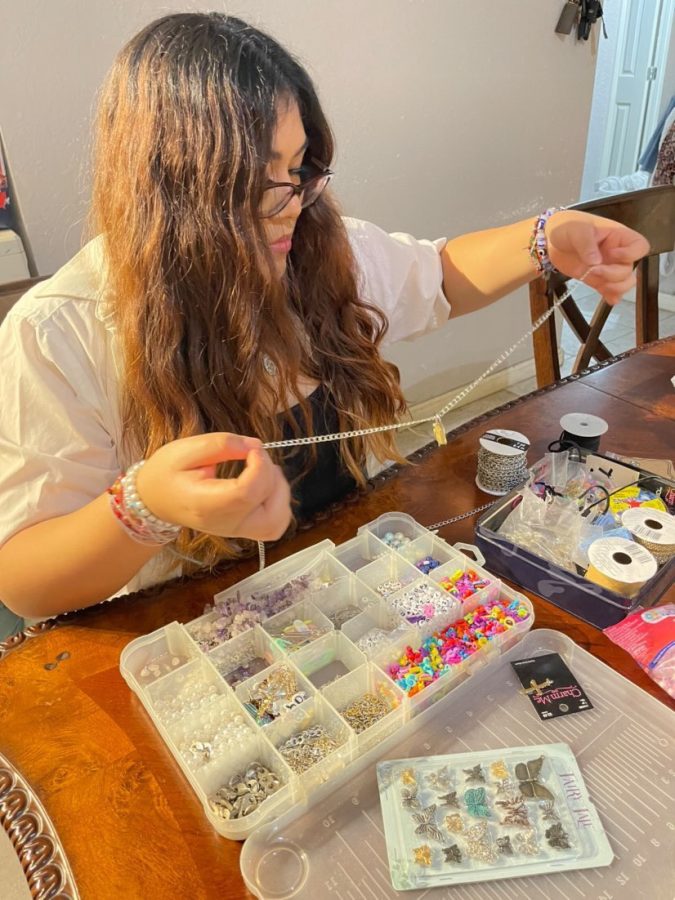 Sophomore Ella Castillo begins to make her handmade necklace. She has a lot of beads, pearls, letters, chains, pendants and string to make her jewelry with.