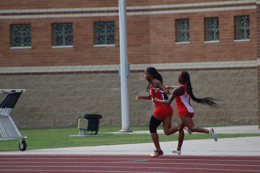 Caliyah Lily and Talia Palmer complete a handoff in the 4x200 relay race. Not pictured but also on the relay team are Takia Palmer and Sarah Gregory.