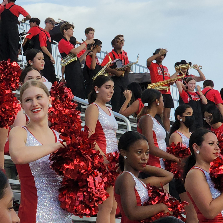 The Belles perform their stand routines while the Mighty Cardinal Band plays. Cowbells, chants, and poms are used to show school spirit towards the football team. 