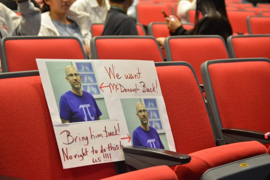 A handmade “Bring Back McDonough  poster is propped up on a seat in the front row of the auditorium. Similar posters were out on display before the meeting started.