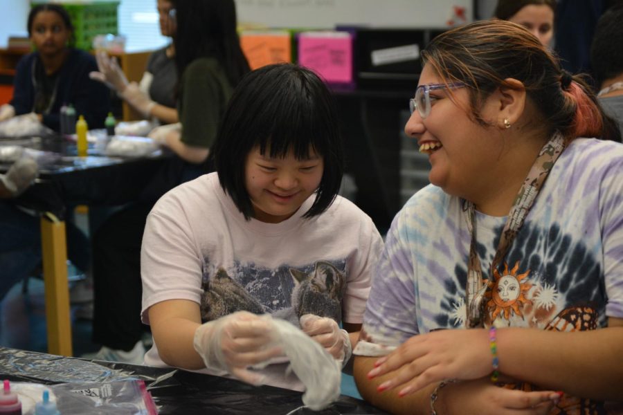 Sophomores Bethany Wong and Dayanna Santibanez wear the gloves before using the dye. The Cardistry Club, Best Buddies and Fashion Club have been planning this event for two weeks.