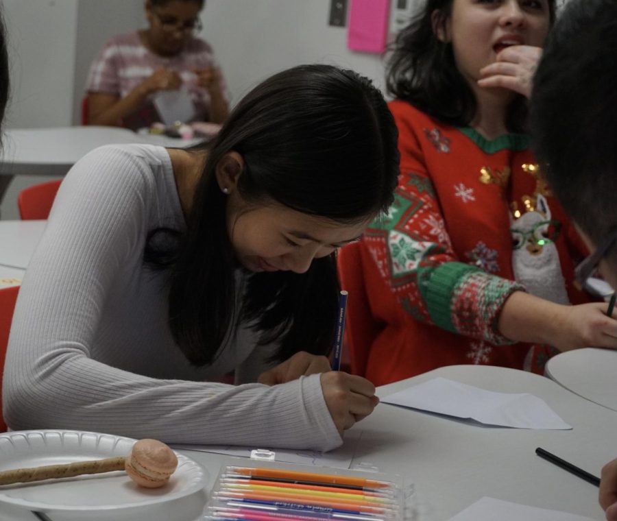 Senior Laura Cheng decorates a card as a part of the card-making activity. There were a variety of markers, stickers and card designs provided to choose from.
