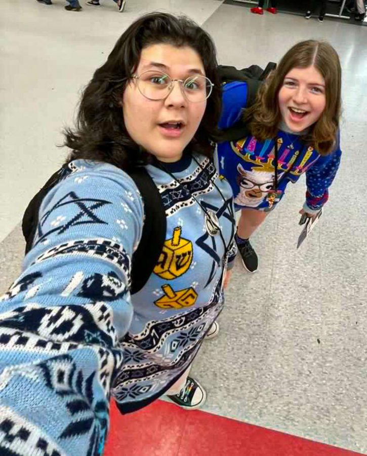 Sophomore Sami Irwin and freshman Samantha Lepow take a selfie to commemorate their Hanukkah-related ugly sweaters for Tuesdays theme: Ugly Sweater Day. Irwin wore a sweater with the Star of David and dreidels, and Lepows sweater included a llama wearing a menorah as a hat.