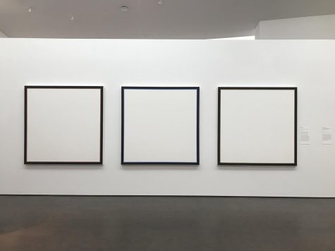 An art piece by Jo Baer hangs in the Museum of Fine Arts. The piece includes three blank canvases with a trim of color around the edges.