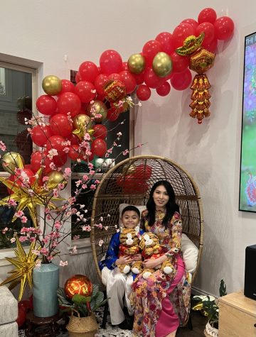 Ms. C. Vu and her son, Chase, wear their ao dais in their home around traditional Tet decorations. Decorations often involve the color red and carry a cultural significance of promoting greater luck and prosperity for the coming new year.