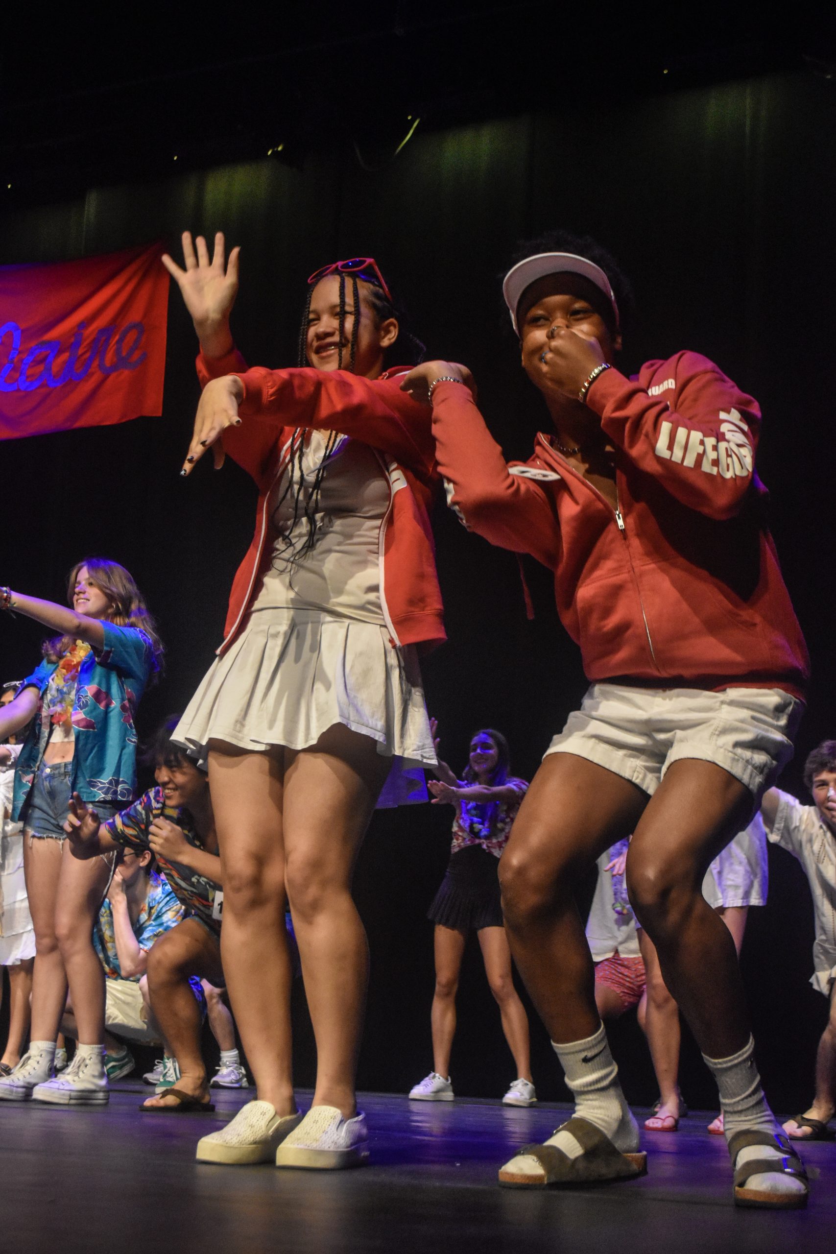 Seniors Zachary Johnson and his escort, Isabel Ajatta, perform a group dance while dressed in beachwear. Johnson was later crowned winner of the 10th annual Mr. Bellaire pageant.