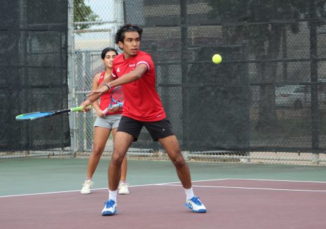 Junior Dhruv Balivada winds his arm back as he prepares to swing at the the incoming tennis ball. He plays doubles alongside sophomore Saachi Gupta.