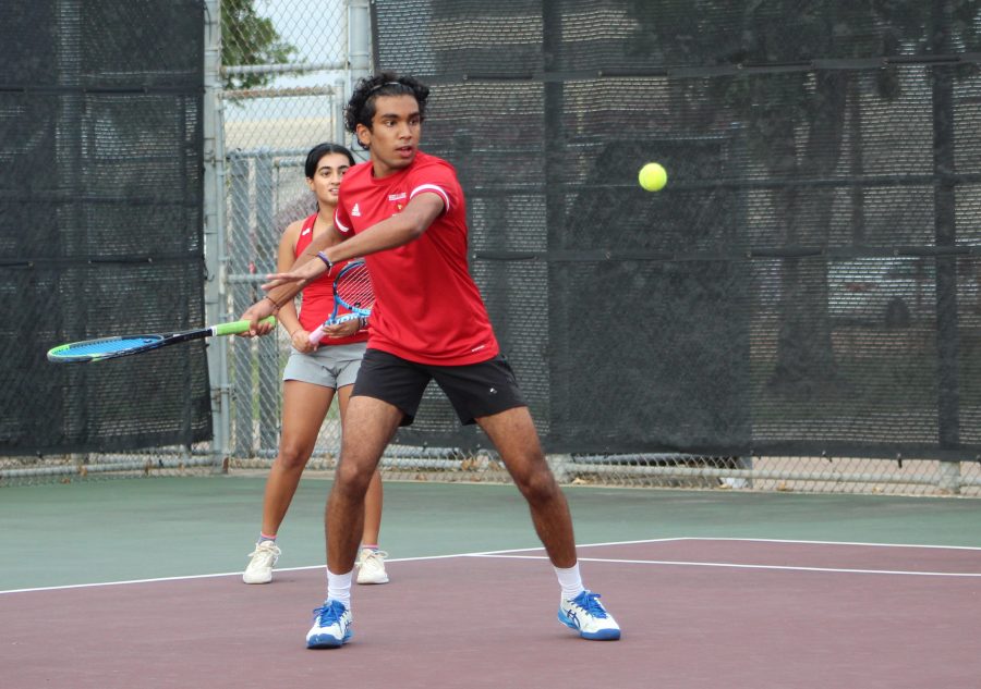 Junior+Dhruv+Balivada+winds+his+arm+back+as+he+prepares+to+swing+at+the+the+incoming+tennis+ball.+He+plays+doubles+alongside+sophomore+Saachi+Gupta.