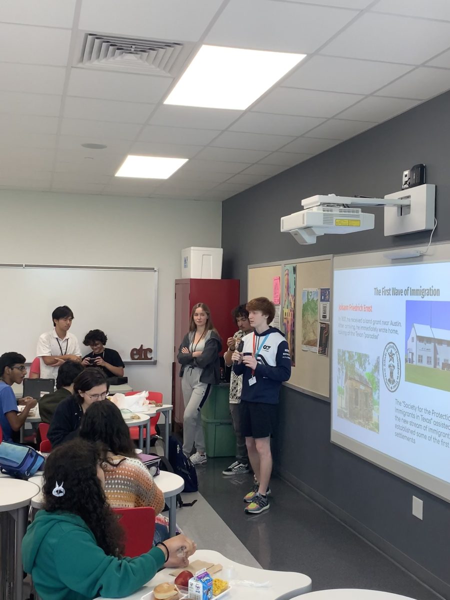 New and old members of the German Club listen attentively as president and junior Andrei Perepelitsa discusses the first wave of German immigration to Texas.