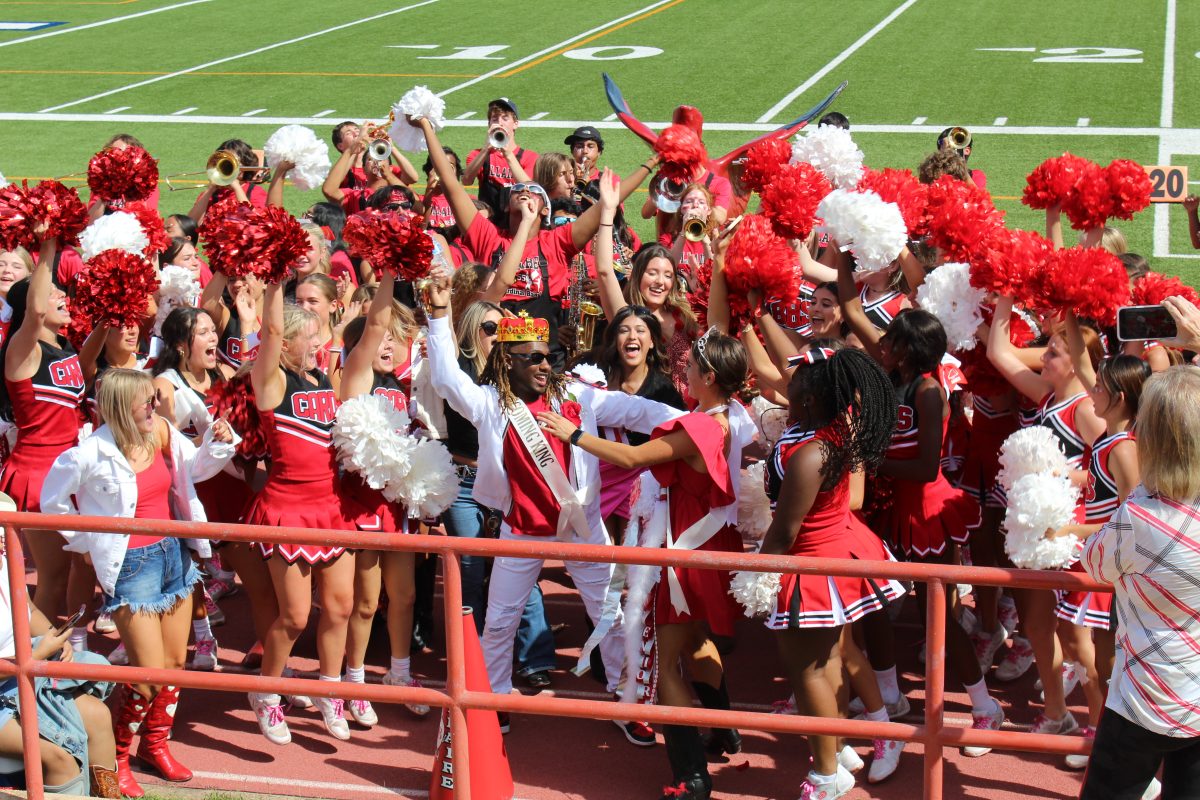 Homecoming King Jermaine Hayden and Homecoming Queen Ainsley Pinkerton dance along with cheerleaders and band members in the hype train as they celebrate the crowning of the 2023 homecoming court nominees. Hayden takes this moment of celebration with Bellaires student body as a key memory from his crowning he will remember in the years to come.