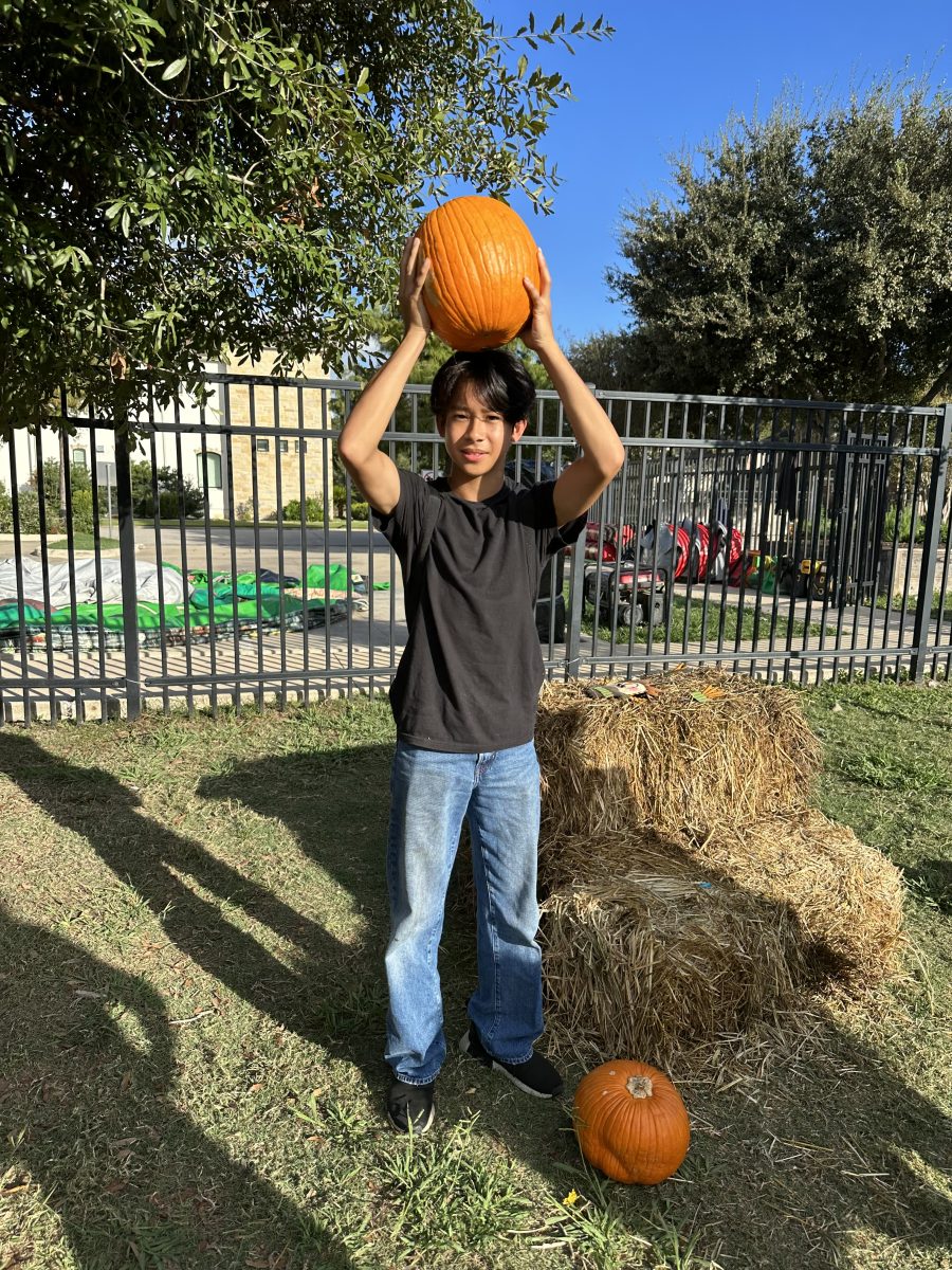 Sophomore+Preston+Lew+helps+move+pumpkins+and+hay+bales+to+the+PTO+Parents+cars+after+the+festival.+Preston+took+photos+with+his+friends+at+the+photo+booth+area+beforehand.