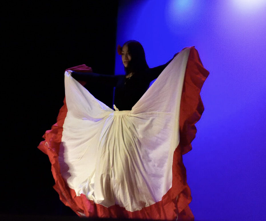 Junior and LSL president Jasmin Garcia shows the audience a Colombian skirt during the Folklórico Cosatarricense. She taught the dance to other club members.