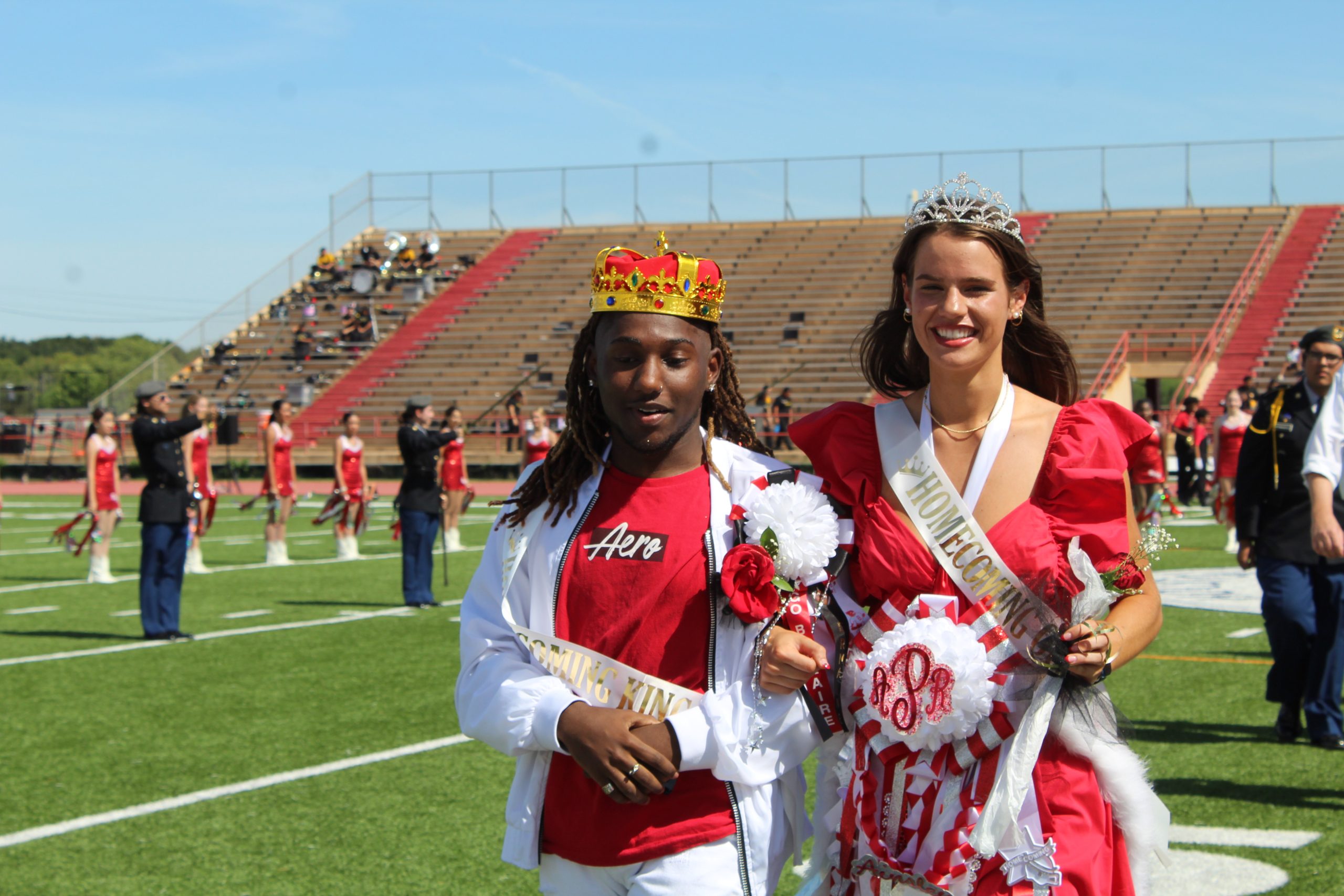 Senior Ainsley Pinkerton walks off Butler stadiums field, shocked she won homecoming Queen as the representative of softball, a team1/4 the size of the Belles, the team represented by another homecoming court nominee. Pinkerton is accompanied by Senior Jermaine Hayden, representing the fine arts and drama departments of Bellaire.