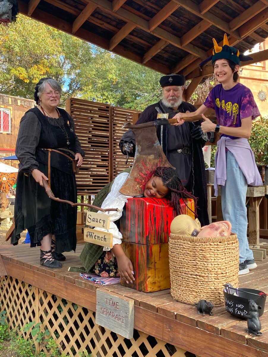 Junior Nicolas Olivares holding an axe that is cutting the head of sophomore Emmerie Napier. At this attraction, the workers also give an offensive medieval nickname to the one on the beheading block.