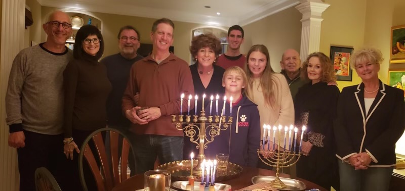 Sophomore Emma Manne and her family a few years ago. This photo was taken after lighting the candles on the seventh night of Hanukkah.