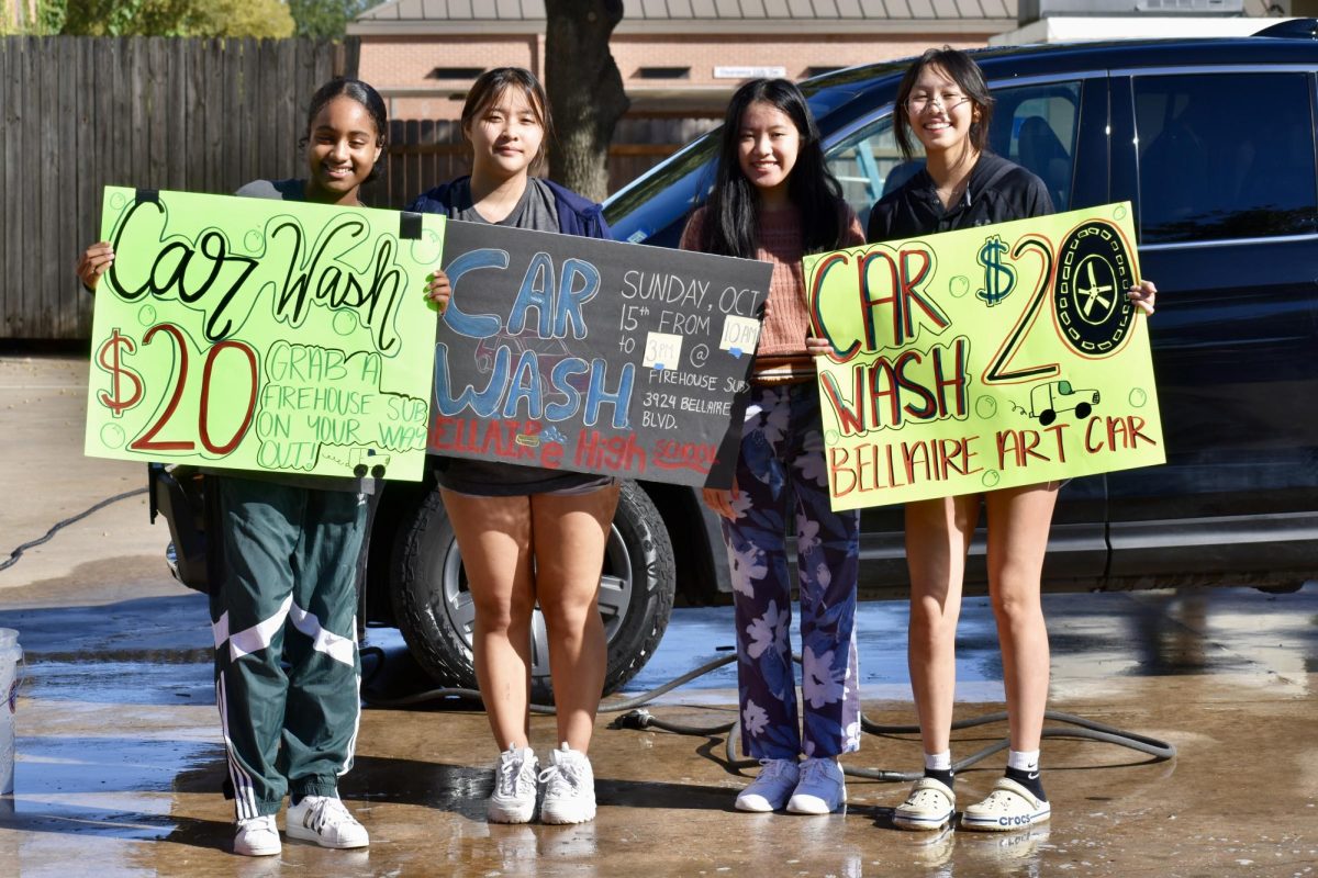 Co-presidents Simone Goffney, Aria Jin, Julie Tang and Cathryn Vera hold up their posters for a photo.