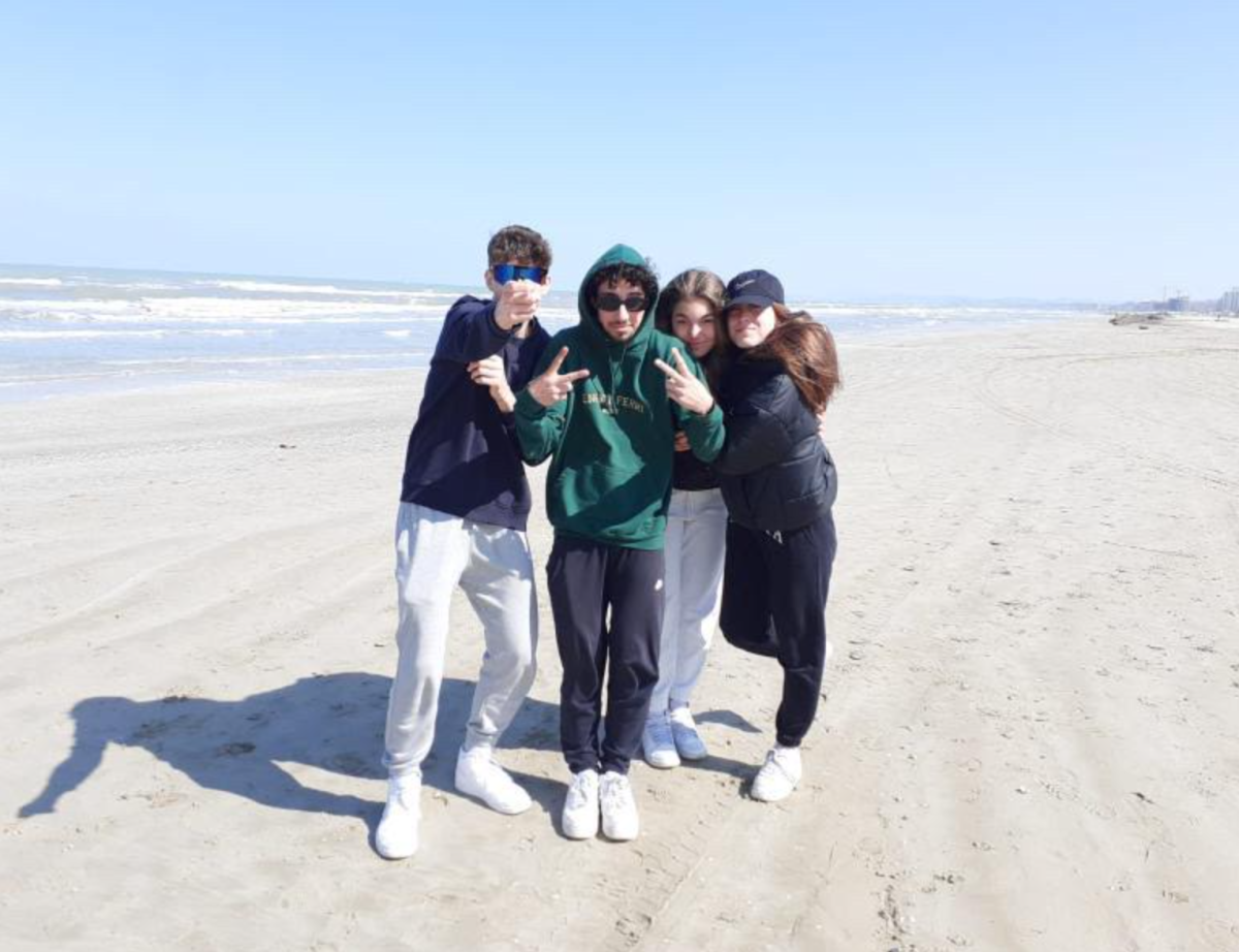Linda poses with her friends at a beach in Italy. The beach is called Spiaggia di Villanova.