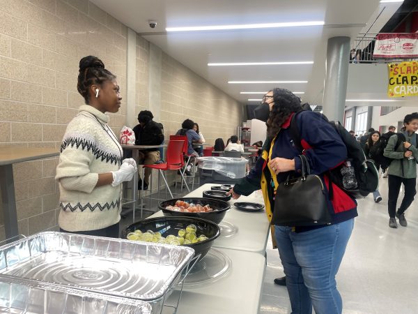 Junior Taylor Robinson connects with teachers and explains to them breakfast options available. Despite the trouble entering the building, Taylor put her gloves on and got to work.