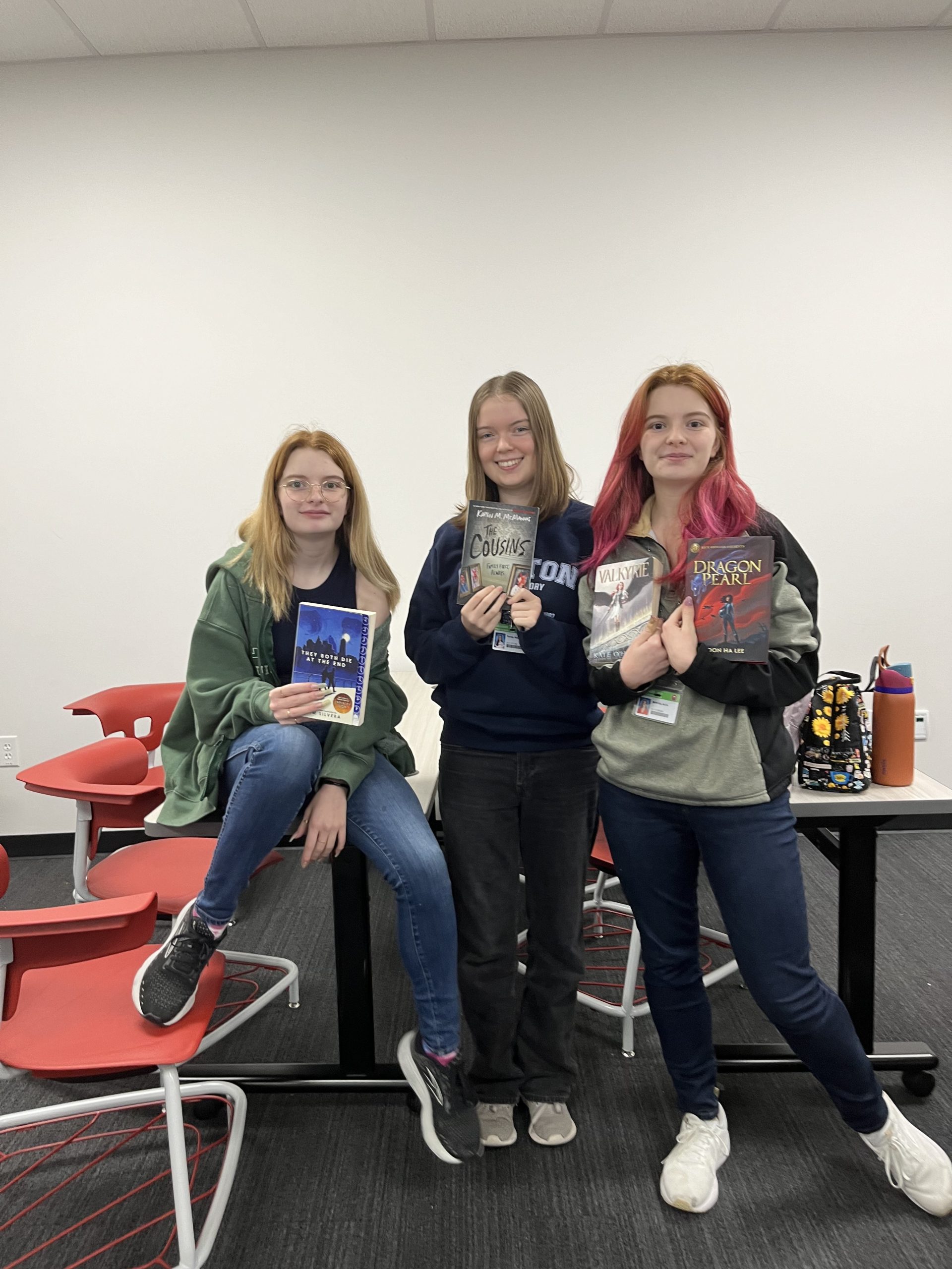 Junior Aoife McBride, right, stands with two other WRITE Club members holding the books they brought to the swap. McBride views WRITE Club meetings as a fun way to harness [her] creative energy.