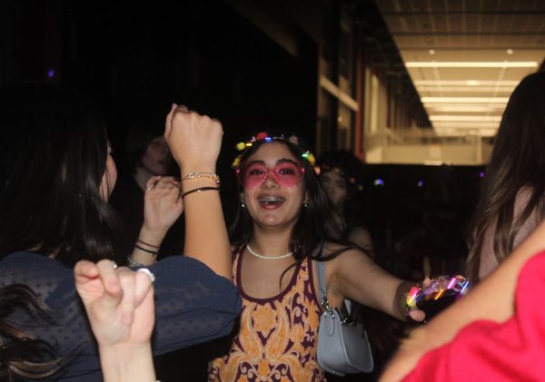 Lala Flores dances at the Spring Fling with her friends. Students were given complimentary heart-shaped glasses and flower crowns as they entered the school.
