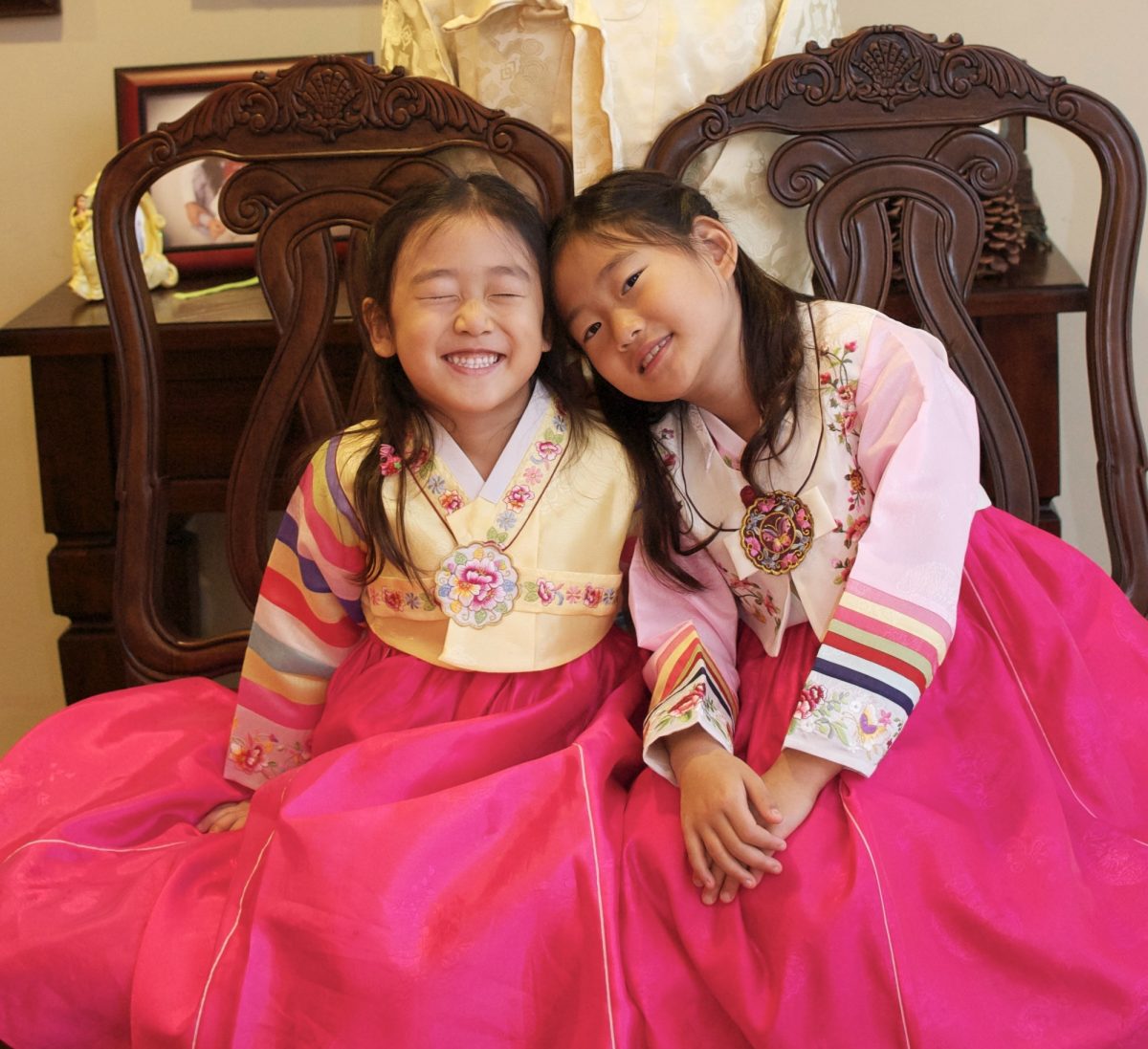 Dressed in vibrant hanbok dresses, my sister and I celebrate Seollal, the Korean New Year. We embrace our shared heritage through sisterly joy.