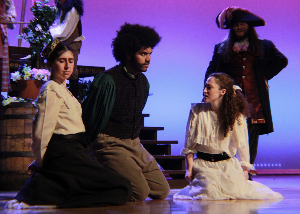 Mrs. Bumbrake (junior Daphne Kaufman) and Alf (senior Joshua Percy) kneel with their hands bound behind their backs as prisoners of Black Stache (senior Brian Smith). They are held in captivity for Stache to gain leverage over Molly (senior Talia Schwartz) and exchange his captives for a treasure chest full of stardust.