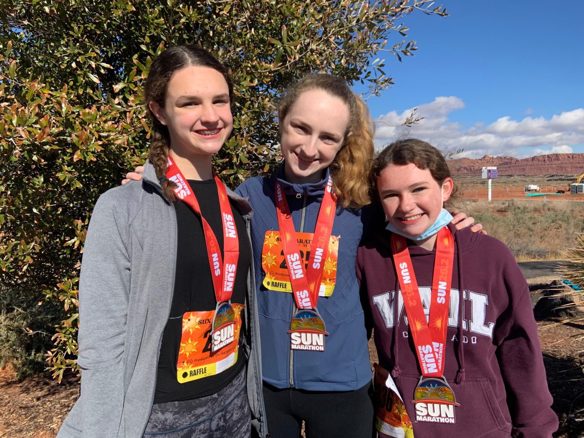 Mackin+%28right%29+stands+with+older+sisters+Caroline+and+Celeste+Mackin+after+her+first+marathon%2C+the+Sun+Marathon.+To+commemorate+the+marathon%2C+Mackin+and+her+family+went+to+get+burgers%2C+then+grabbed+Oreos+and+chocolate+milk+at+the+grocery+store.