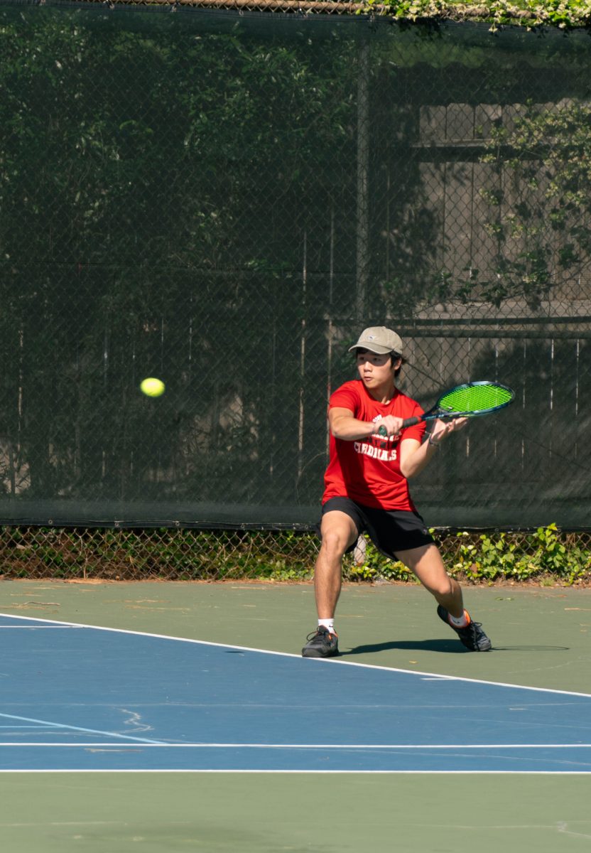 Sophomore Dylan Tran prepares for a backhand slice to return a deep ball. Tran played his match on the outdoor courts at Chancellors Family Center in a boys singles draw. Tran did not win the official draw, but he did go on to win the consolation one.