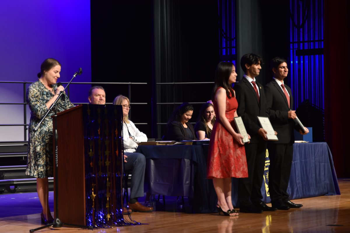 NHS co-advisor Jennifer Kuhleman recognizes NHS scholarship semi-finalists seniors Katelyn Ta,  Aaditya Krishna and Akshay Kapur (left to right). All three of the seniors demonstrated the four pillars of NHS during their time at Bellaire.