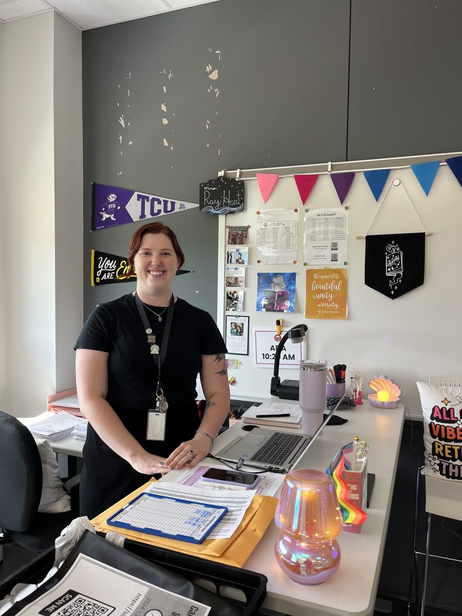 Mrs. Ray-Hart, a new AP Literature teacher at Bellaire, stands behind her desk in her brightly decorated classroom.