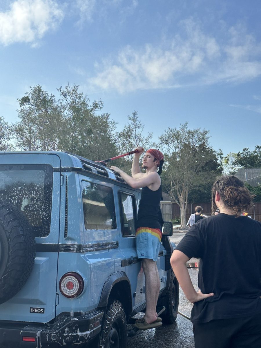 Senior and Choir President Ronan Carrettin washes a Jeep while on shift. The car wash was intended to raise funds for choir events and competitions, such as UIL. (Photo provided by Teresa Cheng)