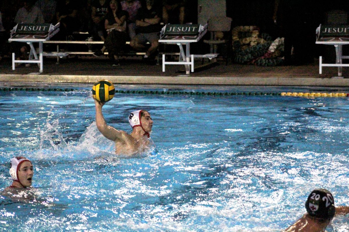 Sophomore Jackson Hill propels his body out of the water, attempting to score a goal for the Cardinals against Strake Jesuit. Hill scored one point for Bellaire.