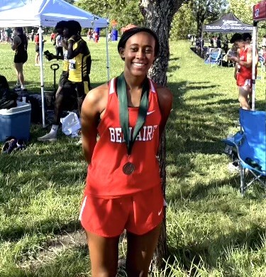 Sophomore Charlotte Hart finishes a 5K at Bear Creek Park. She receives a medal for finishing. 