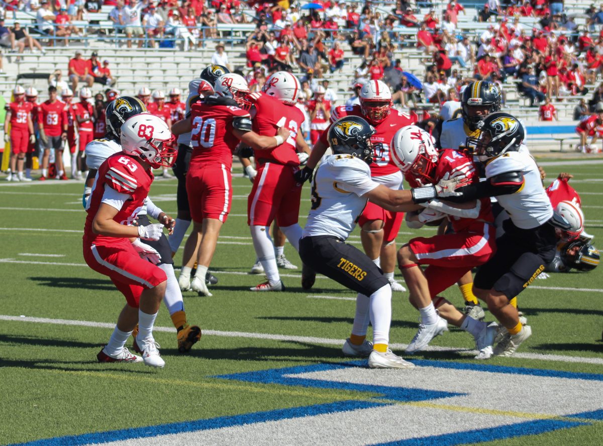 Freshman Jake Brasington gets blocked by two defensemen at the homecoming game. Brasington primarily plays running back.