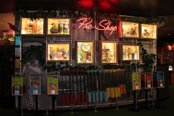 The retro theme of the mini golf course is truly accentuated in the area to check out putters. You can pick your length and get the golf balls out of the coin slot machines.