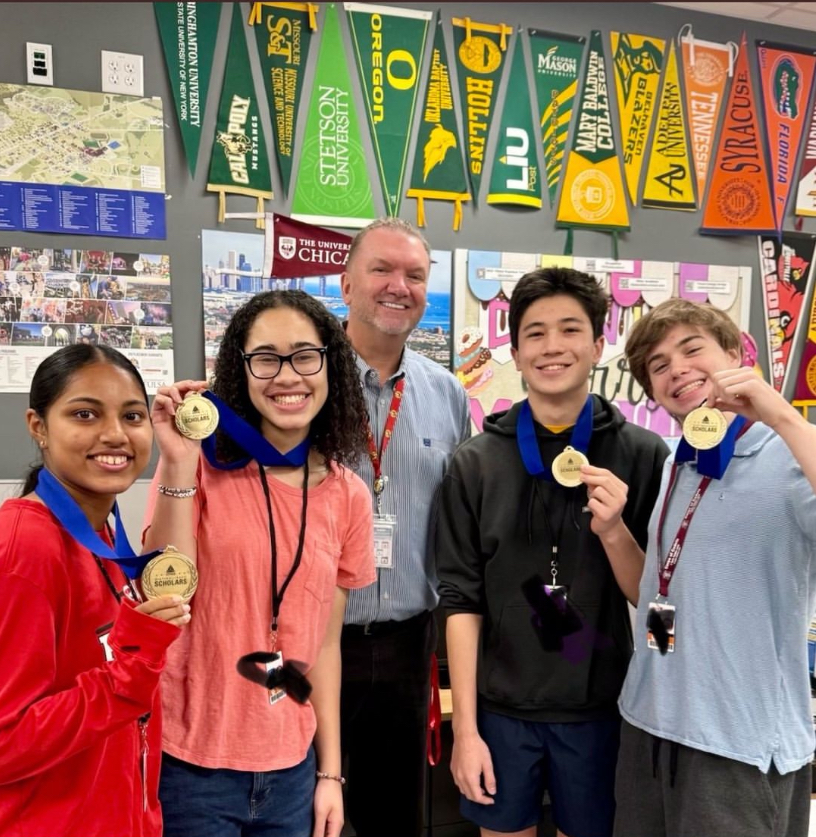 [Seniors Grishma Ooman, Claire Bradford, Andrew Sazykin and Weston Benner hold up their CITGO Scholarship medals with Principal Michael Niggli. They were awarded the scholarship in the college center on Sept. 15. 
(Photo provided by: Bellaire High School)].