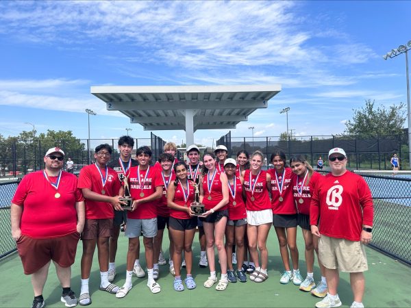 The Cardinals pose with their trophy after winning the district. They are accompanied by varsity coach Anthony Kirk (right) and junior varsity coach Alex Brown. (left)