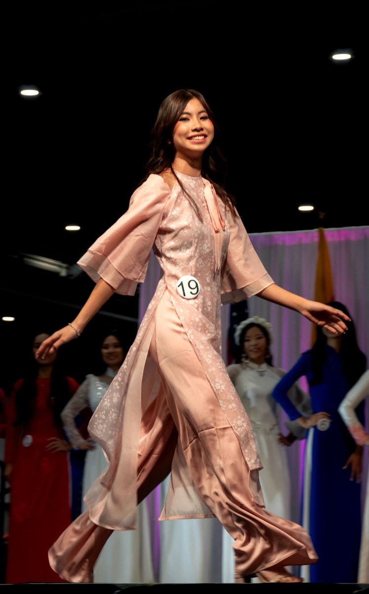 Junior Emma Tran walks across the stage during the Miss Teen Viet pageant while showcasing her áo dài at the Vietnamese Cultural Festival on Sept. 14 at NRG Stadium. This was Tran's first year competing, and she was assigned the number 19.