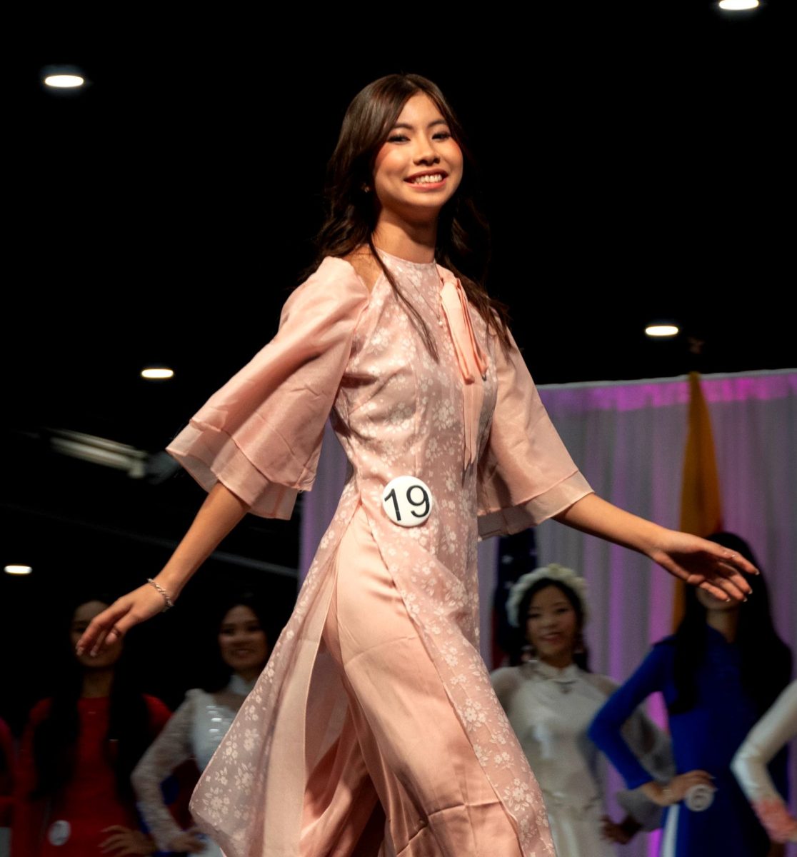 Junior Emma Tran walks across the stage during the Miss Teen Viet pageant while showcasing her áo dài at the Vietnamese Cultural Festival on Sept. 14 at NRG Stadium. This was Tran's first year competing, and she was assigned the number 19.