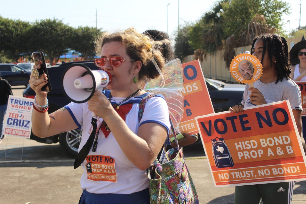 About 20 opponents to the HISD bond gathered at the Community Voices for Public Education's Halloween-themed "Haunt the Polls" event to encourage voters to vote against the bond. Attendees marched in the parking lot of the Metropolitan Multi-Service Center chanting call-and-response protests.