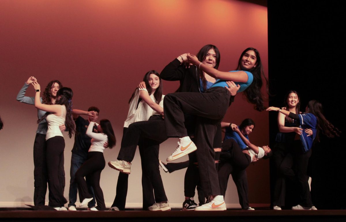 Junior Giselle Fernandez-Canales (front left) and sophomore Nisha Thukral (front right) dance bachata with Esther Galo's first period AP Spanish Language class. All six of Galo's Spanish classes performed in or helped decorate for the Hispanic Heritage Month celebration.